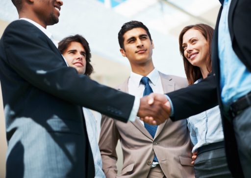 Portrait of hand shake between business associates with confident team